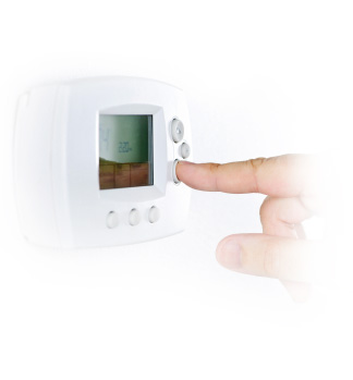 A finger adjusting the temperature on a thermostat 